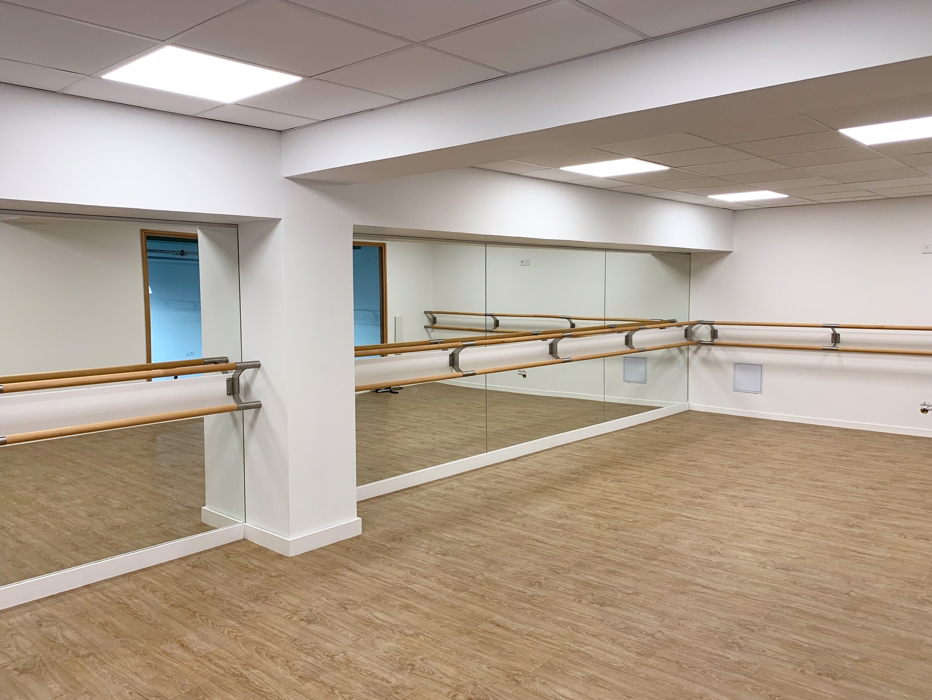 Salle de Pilates et Yoga avec miroirs toute hauteur et barre de danse